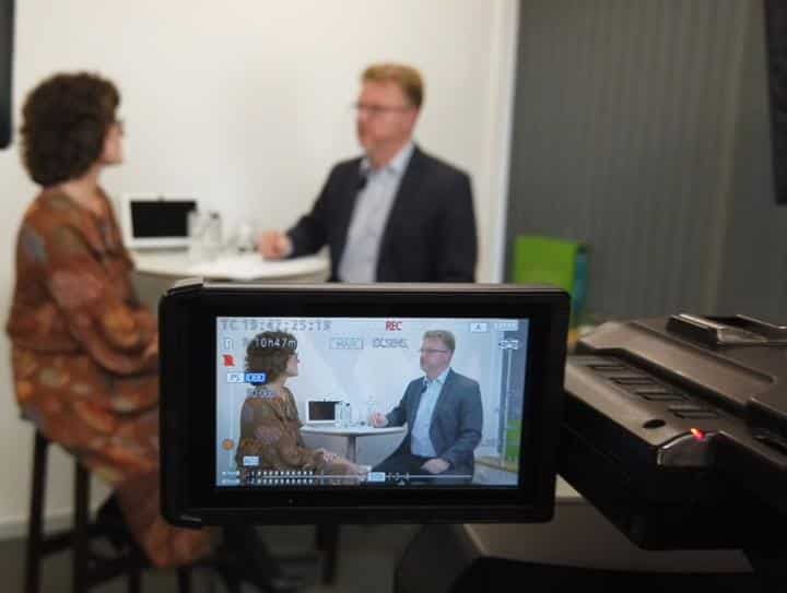 Video camera recording two people in interview meeting