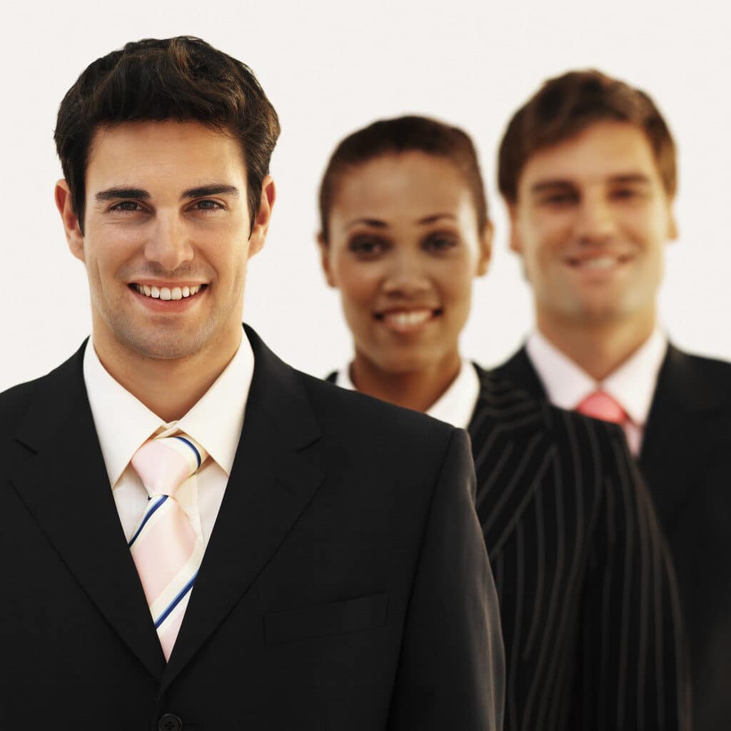 Front view portrait of three business executives smiling --- Image by © Royalty-Free/Corbis